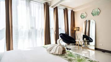 Une chambre d’hôtel avec un grand lit, une chaise, une lampe et un miroir.
