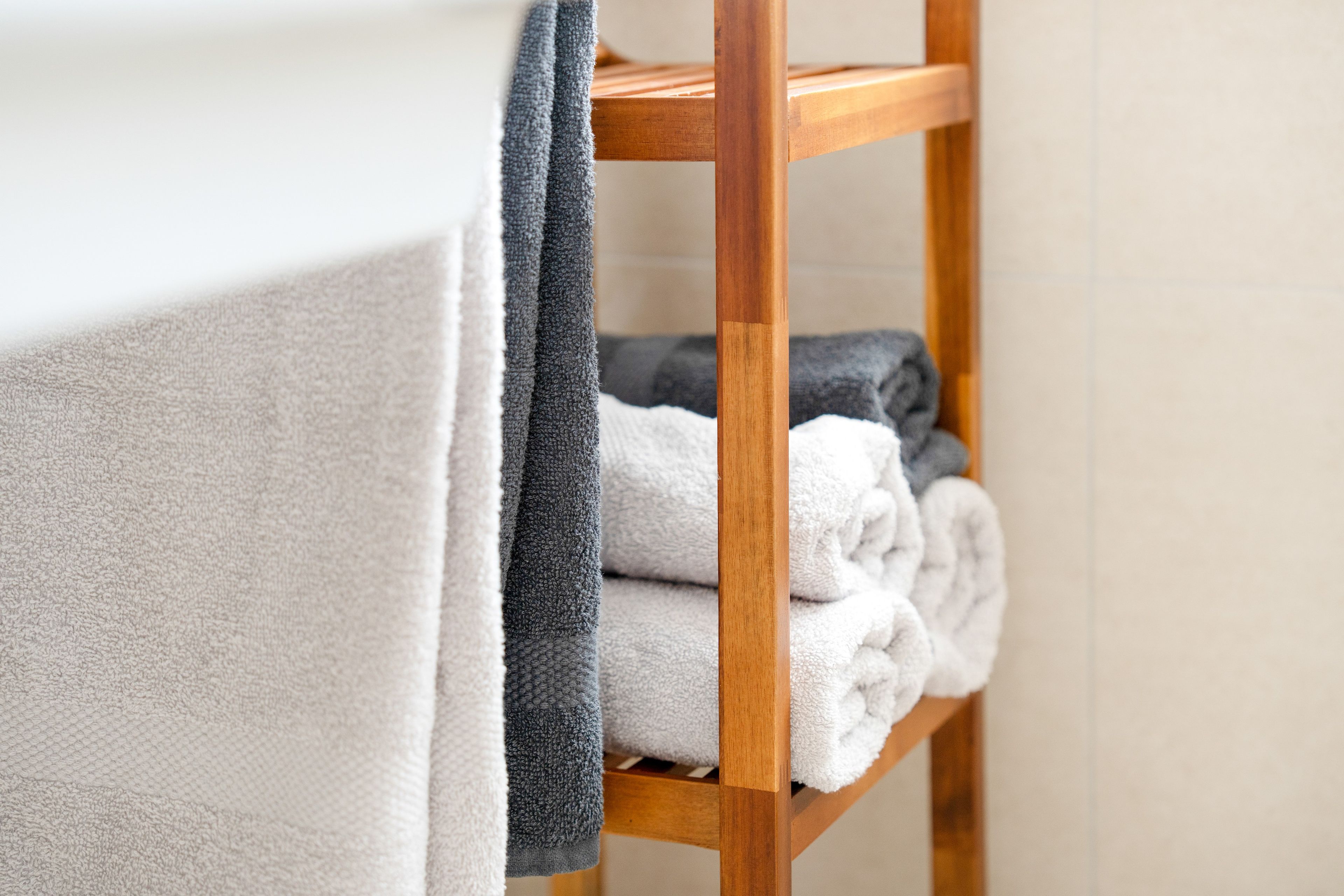 A wooden shelf with folded towels.