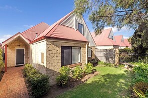 A residential house with a stone facade, a red roof, and a well-maintained garden. - Clearwater Coastal: luxury beachfront getaway, walk to town (Dunsborough)