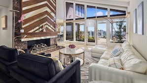 A modern living room with a fireplace, comfortable seating, and large windows offering a view. - 4500SF Dream Home｜Close to Disney｜Skyline View (Santa Ana)