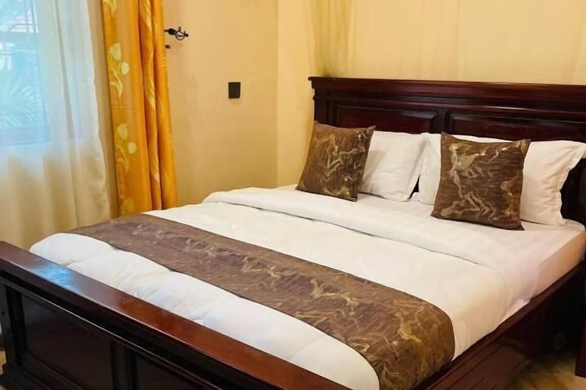 A bed with a wooden frame, a white mattress, and a brown decorative cover.