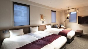 A hotel room with two beds, a flat-screen TV, a desk, and a lamp. - ALPHABED INN Otaru Ekimae (Otaru)