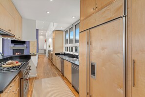 Une cuisine moderne avec des meubles en bois, des appareils en acier inoxydable et un îlot central.