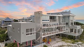 Une propriété en bord de mer, composée de plusieurs étages, dotée d’une piscine, d’un espace extérieur aménagé et offrant une vue sur l’océan.