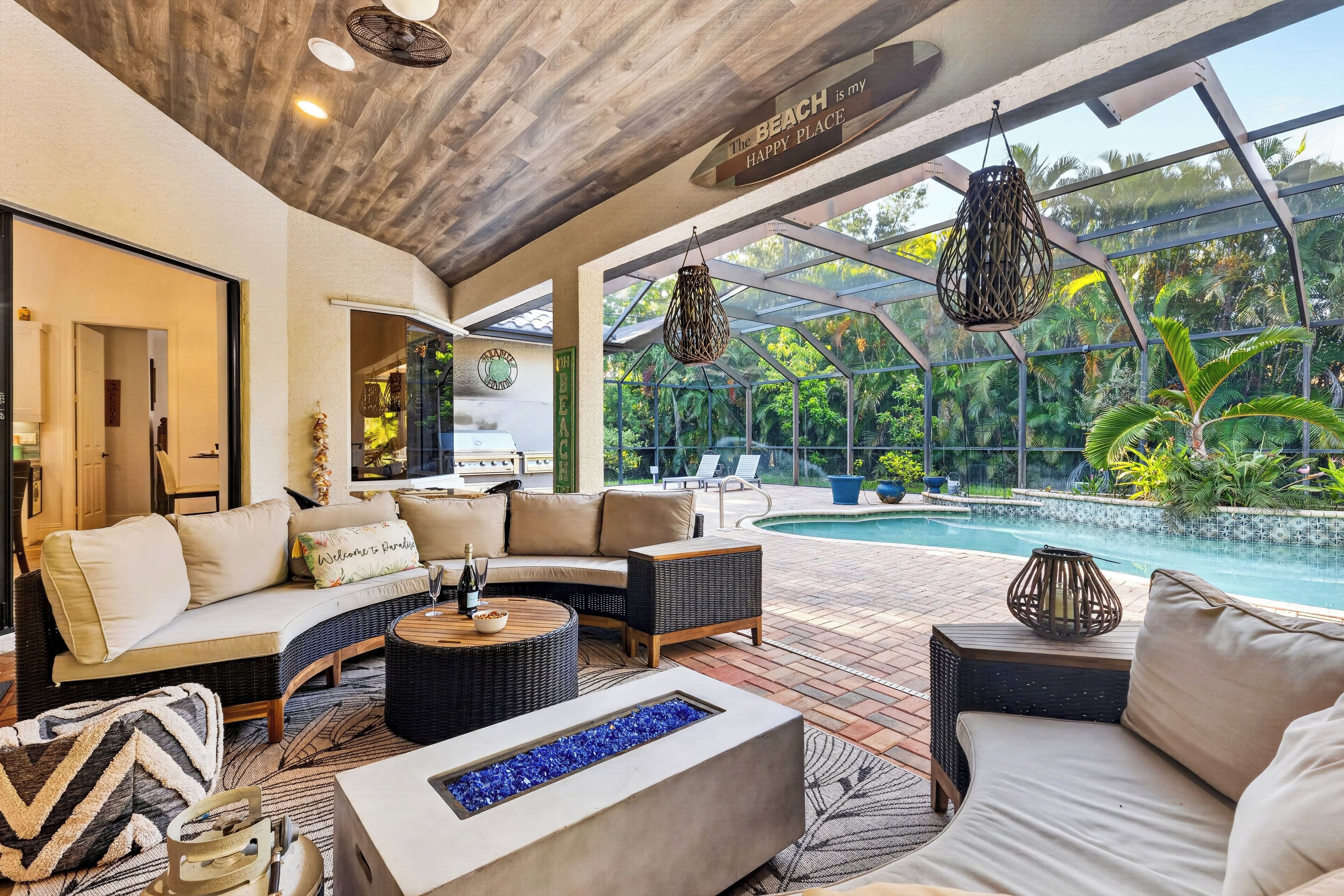 A poolside lounge with a sofa, a coffee table, and a fire feature.