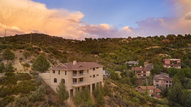 Zona residencial con casas en una ladera, rodeada de vegetación.