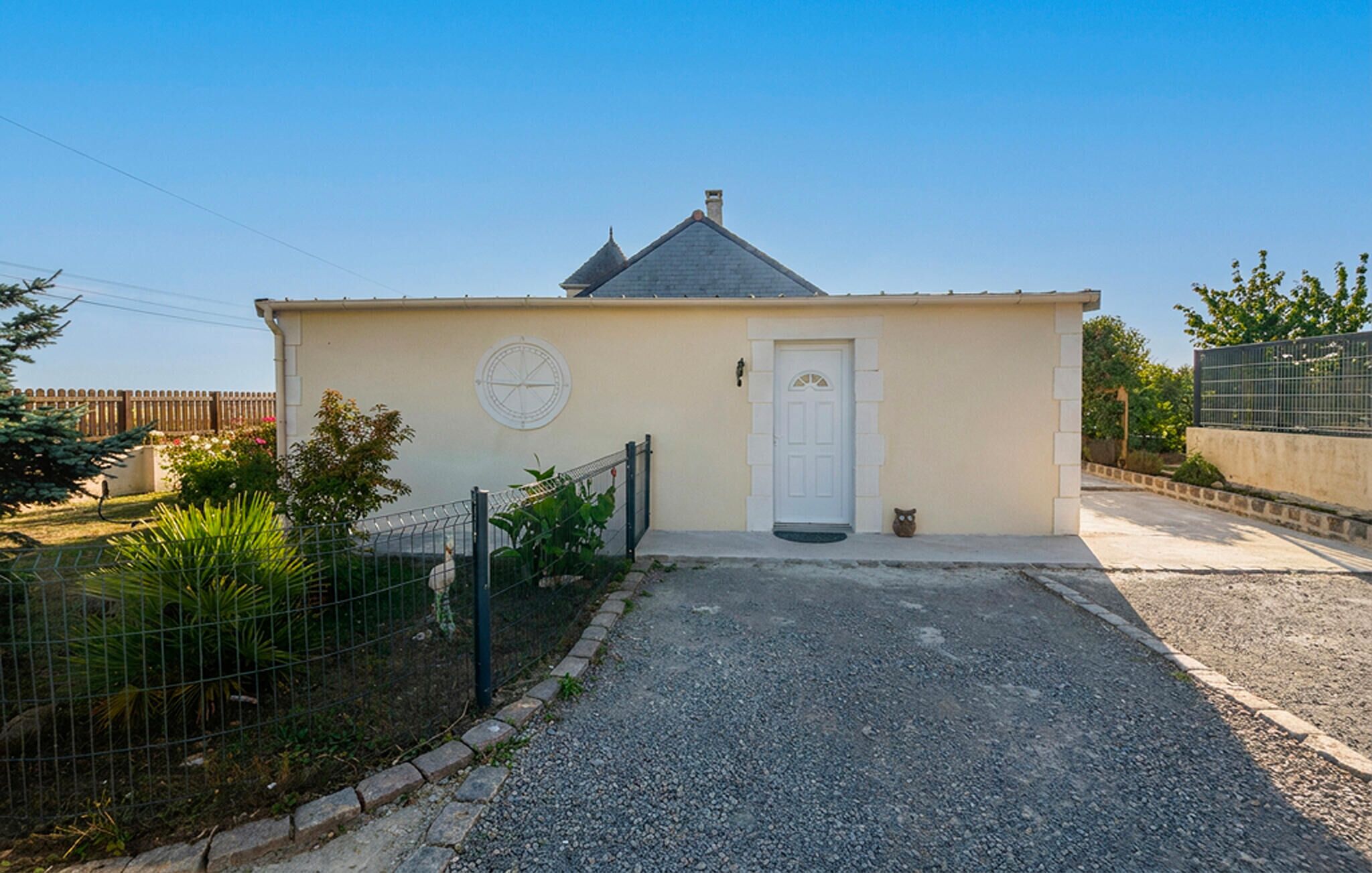A small, single-story building with a white door and a circular window on the facade.