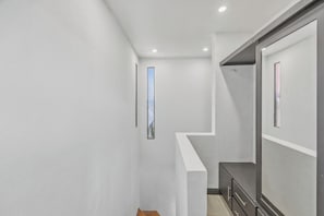 A narrow hallway with white walls and a wooden bench. - 3 bdm*3.5 bath*short walk to the beach*pool*quiet (Tamarindo)