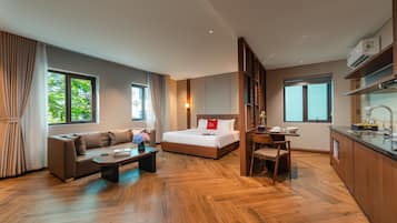 Una habitación de hotel moderna con sofá, cama, zona de comedor y cocina.