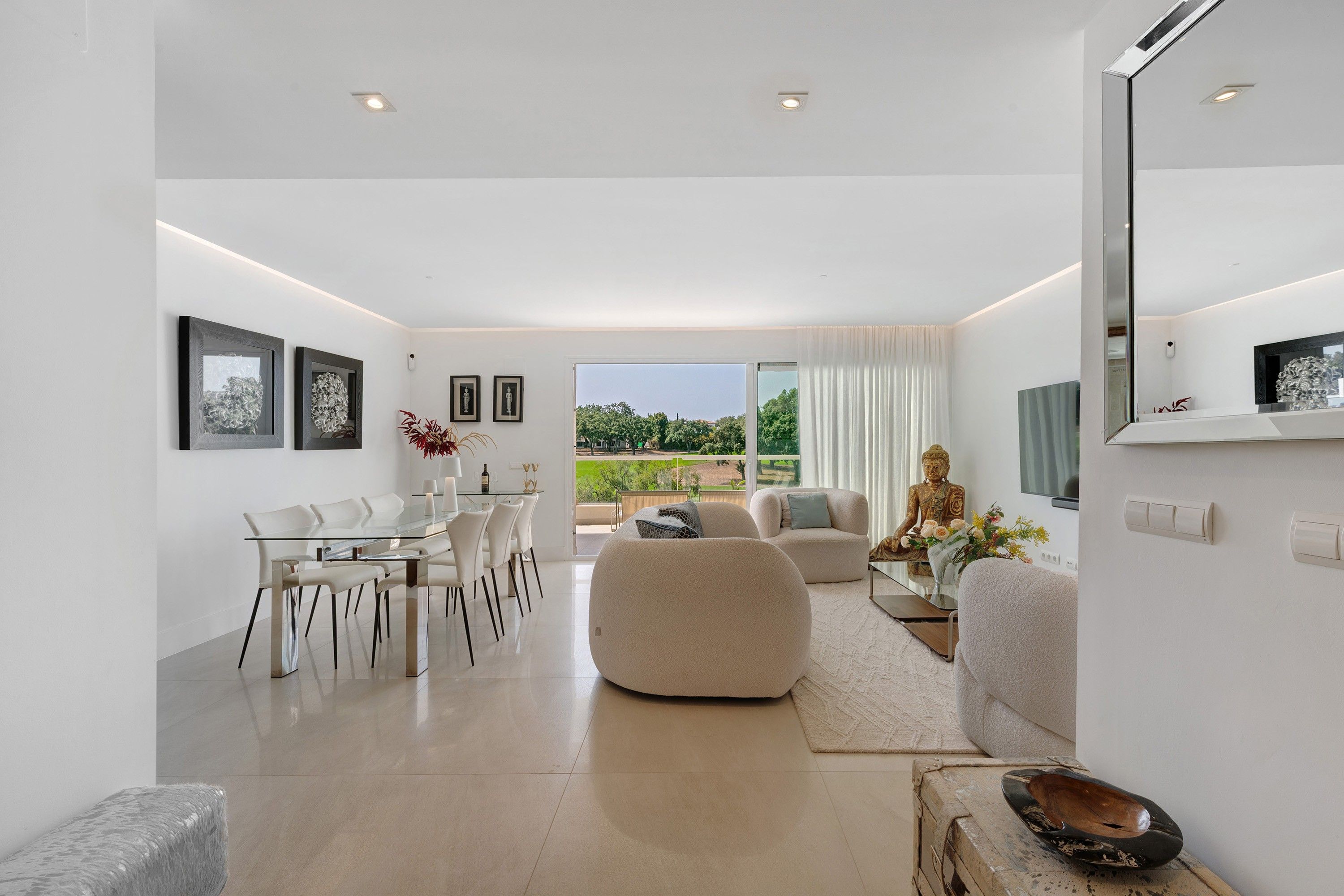 Un interior moderno con comedor, asientos y vistas amplias a través de grandes ventanales.