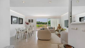 Un interior moderno con comedor, asientos y vistas amplias a través de grandes ventanales.