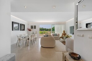 Un interior moderno con comedor, asientos y vistas amplias a través de grandes ventanales.