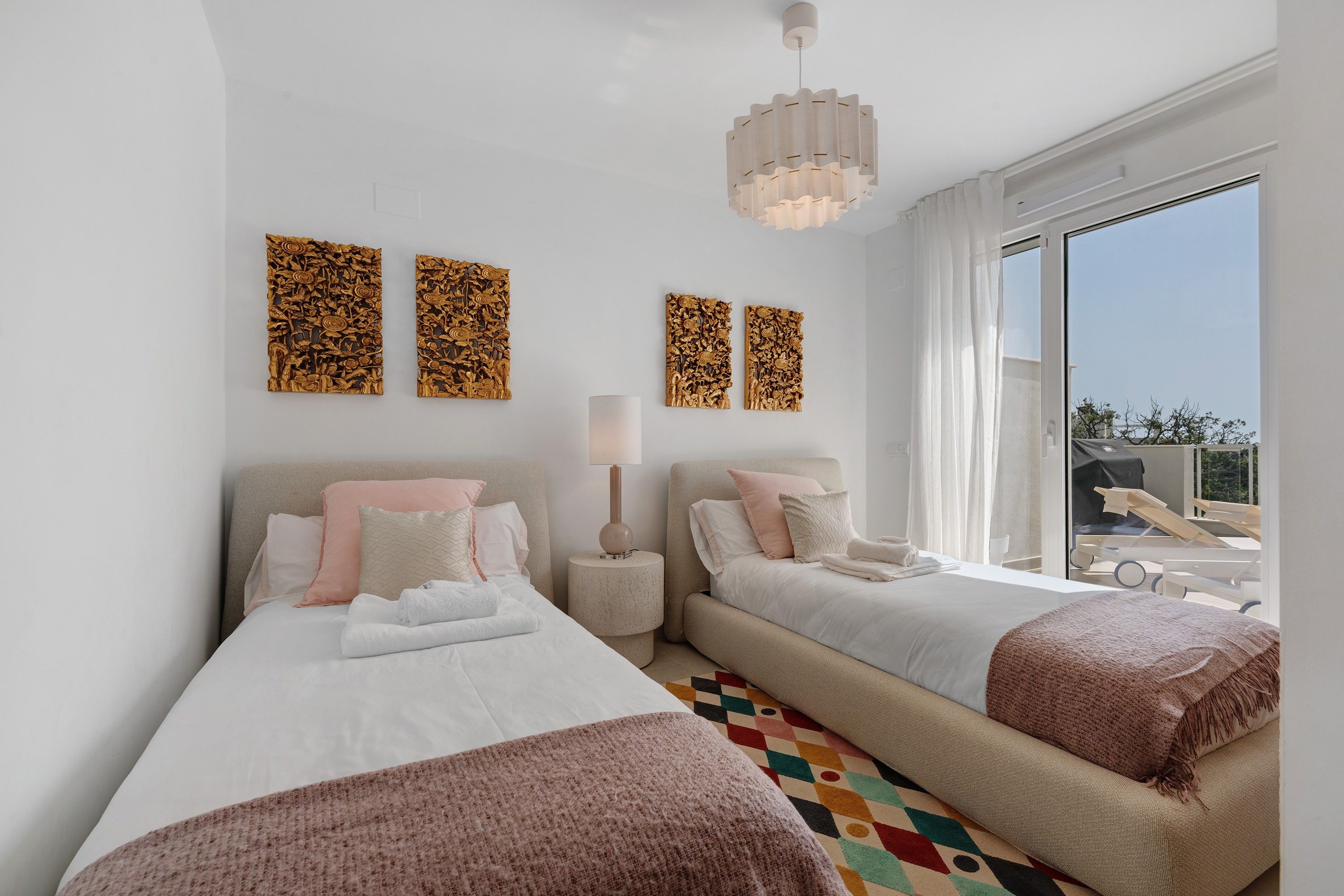 Habitación de hotel con dos camas, un ventanal amplio y decoración mural.