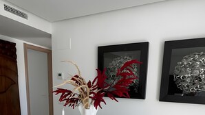 A modern dining area with a glass table, white chairs, and a vase with red foliage. - Holiday Home 'Beautiful House in Emerald Green' with Sea View, Wi-Fi and Air Conditioning (San Roque)