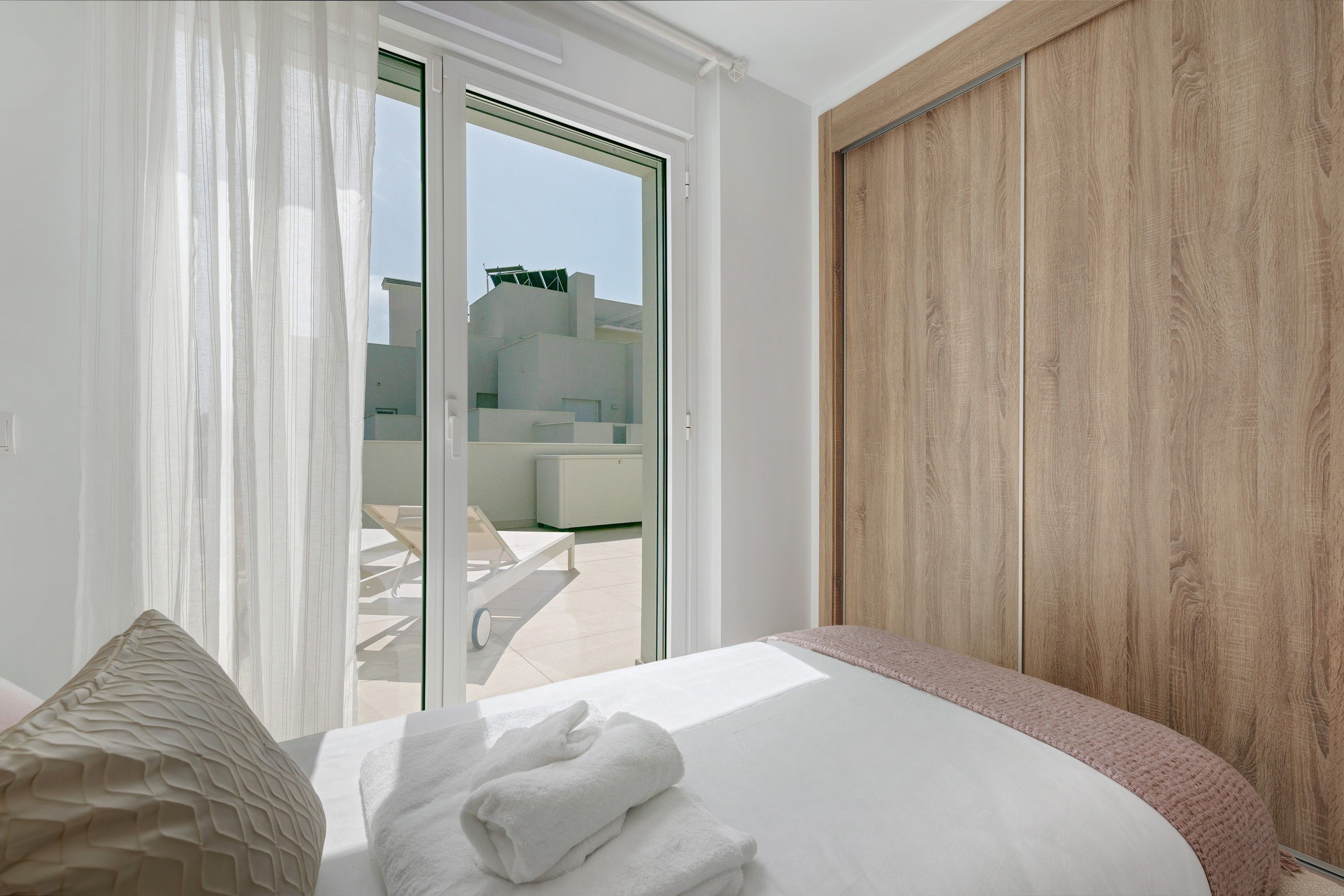 Una habitación de hotel con una cama, vistas al exterior y una pared de madera.