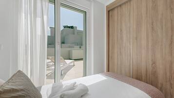Una habitación de hotel con una cama, vistas al exterior y una pared de madera.