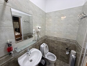 A bathroom with a sink, toilet, and a mirror. - Enjoy Hotel (Tashkent)