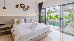 A modern bedroom with a large bed, a view of a swimming pool, and a balcony with plants. - Majys 4 Villa by Tasvan (Badung)