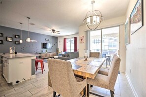 Een moderne keuken met een eethoek, een plafondventilator en een groot raam.