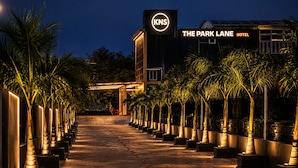 Ein Hotel Eingang mit einem Schild für 'The Park Lane Hotel' und dem Logo 'KNS'.