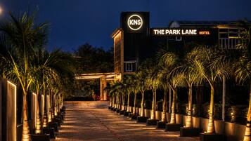 A hotel entrance with a sign for 'The Park Lane Hotel' and a logo for 'KNS'.