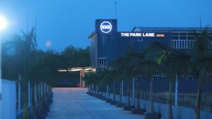 A hotel entrance with a sign for 'The Park Lane Hotel' and a visible logo for 'KNS'.