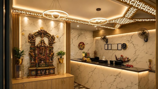 A reception area with a marble wall, a decorative statue, a reception desk, and a patterned floor.