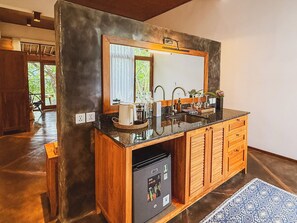A modern kitchen with a built-in dishwasher, wooden cabinets, and a large mirror above the sink.