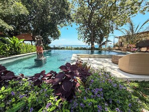 A pool area with a statue, surrounded by lush greenery and a view of the sea. - Exclusive 2-Bedroom Suite with Free Daily Breakfast in Pemuteran, North Bali (Pemuteran)