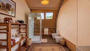Une salle de bain sur le thème du safari, avec une douche en verre, une étagère en bois où sont posées des serviettes et un tapis tissé.