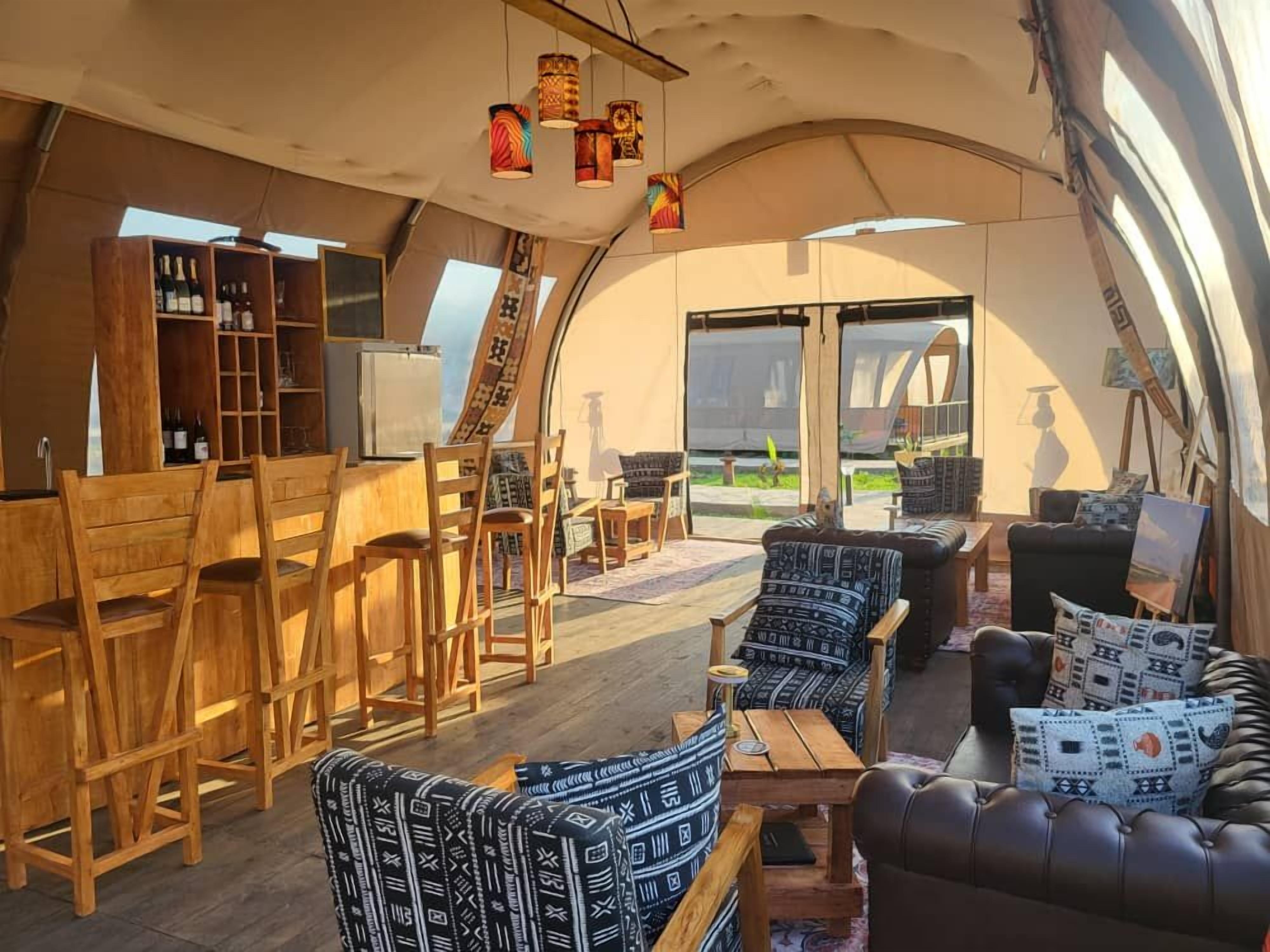 Un ambiente acogedor con muebles de madera, una zona de bar y vistas al exterior.