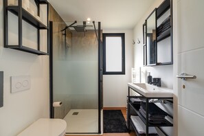Ein kleines Badezimmer mit Dusche, Toilette und Waschbecken.