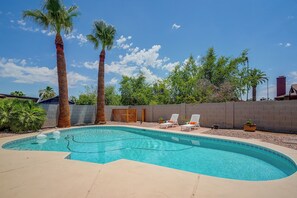 A swimming pool with two palm trees, a wooden fence, and a clear blue sky. - 'Twin Palms' Family Oasis in Glendale (Glendale)