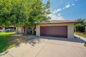 A residential garage with a brown door, a driveway, and a tree in the foreground. - 'Twin Palms' Family Oasis in Glendale (Glendale)