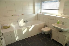 Un baño con bañera, inodoro y lavamanos.