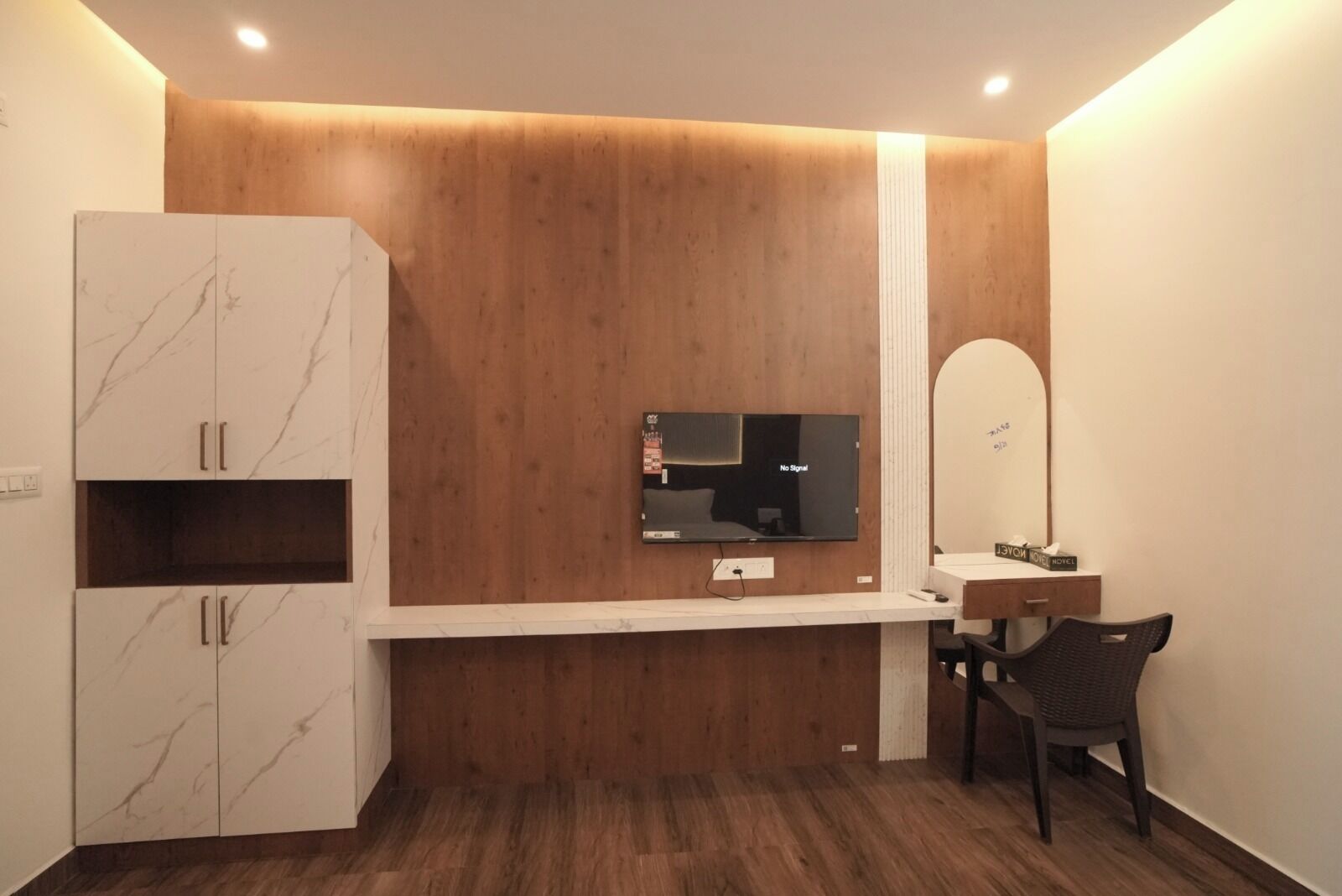 Un baño moderno con tocador de madera, un espejo, una televisión y un armario.