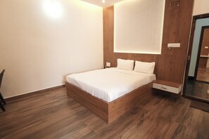 Quarto moderno com estrutura de cama de madeira, roupa de cama branca e mesa de cabeceira.