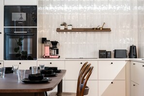 Een moderne keuken met een Bosch oven, een koffiezetapparaat en een broodrooster.