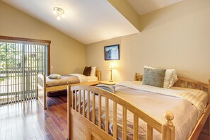 A bedroom with a large bed, a smaller bed, a window with blinds, a picture on the wall, and a ceiling light. - Dock + Hot Tub! Waterfront Lake Tahoe Getaway (South Lake Tahoe)