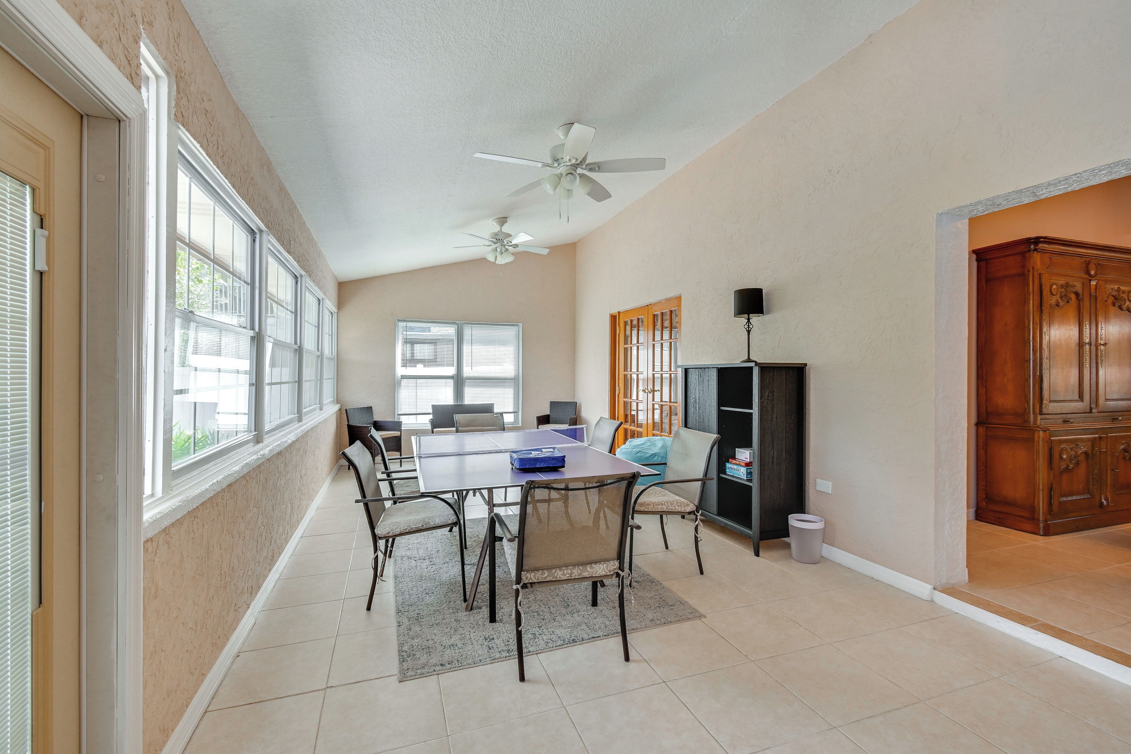 A dining area with a table, chairs, and a ceiling fan.