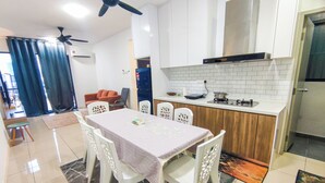 Una cocina moderna con armarios blancos, una mesa de comedor con sillas y un ventilador de techo.