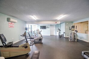 Ein Fitnessstudio mit verschiedenen Trainingsgeräten, darunter Laufbänder, Ergometer und Crosstrainer.