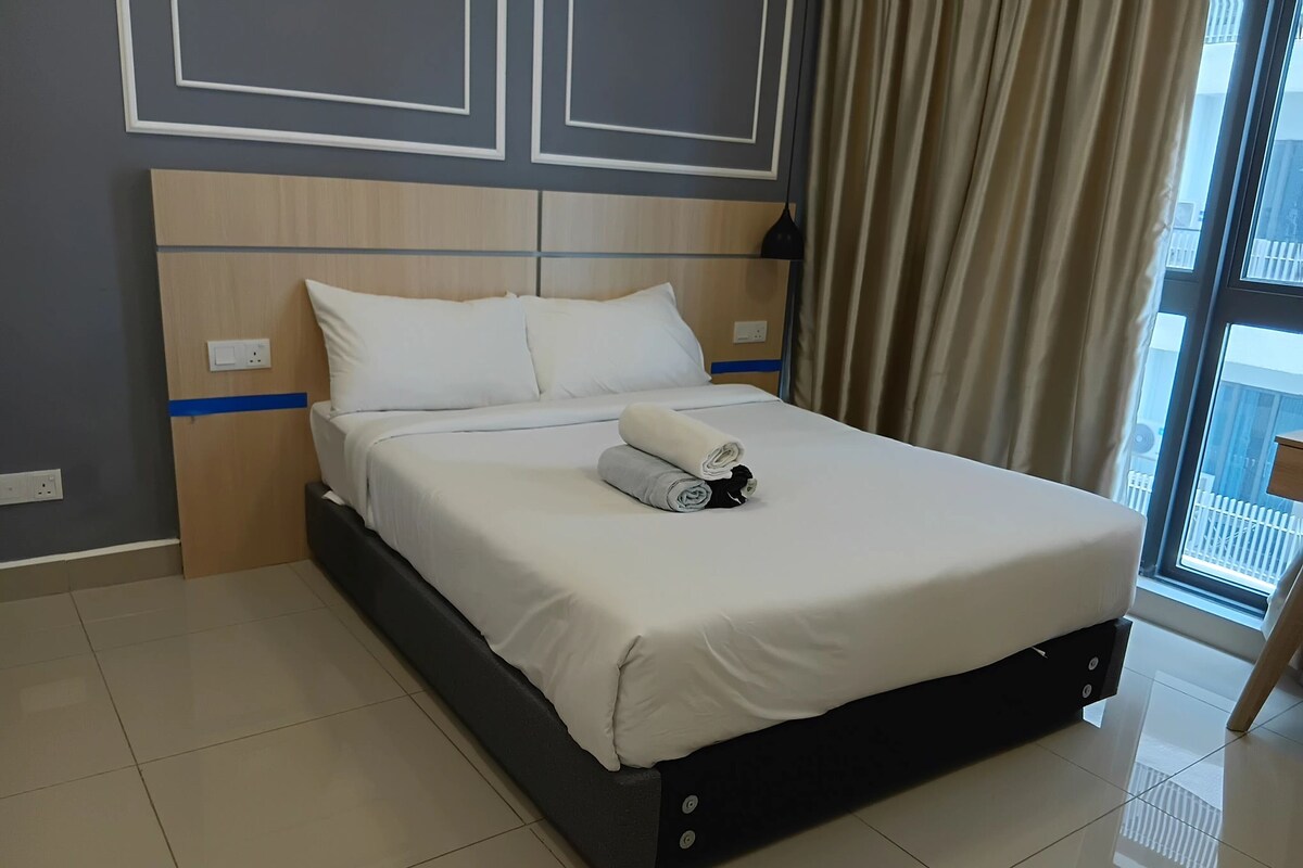 Ein Hotelzimmer mit einem großen Bett, einem Kopfteil mit geometrischem Muster, einem Fenster mit Vorhängen und einem gefliesten Boden.