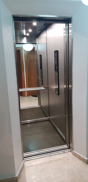 An elevator with metallic doors and a control panel. - 2br Kingbed Kids play area No Surgery (Santo Domingo)