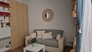 A living room with a sofa, a coffee table, a bookshelf, and a mirror on the wall. - The Oasy in the Lake (Lazio)