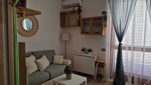 A living room with a sofa, a small table, a lamp, and a cabinet with glass doors. - The Oasy in the Lake (Lazio)