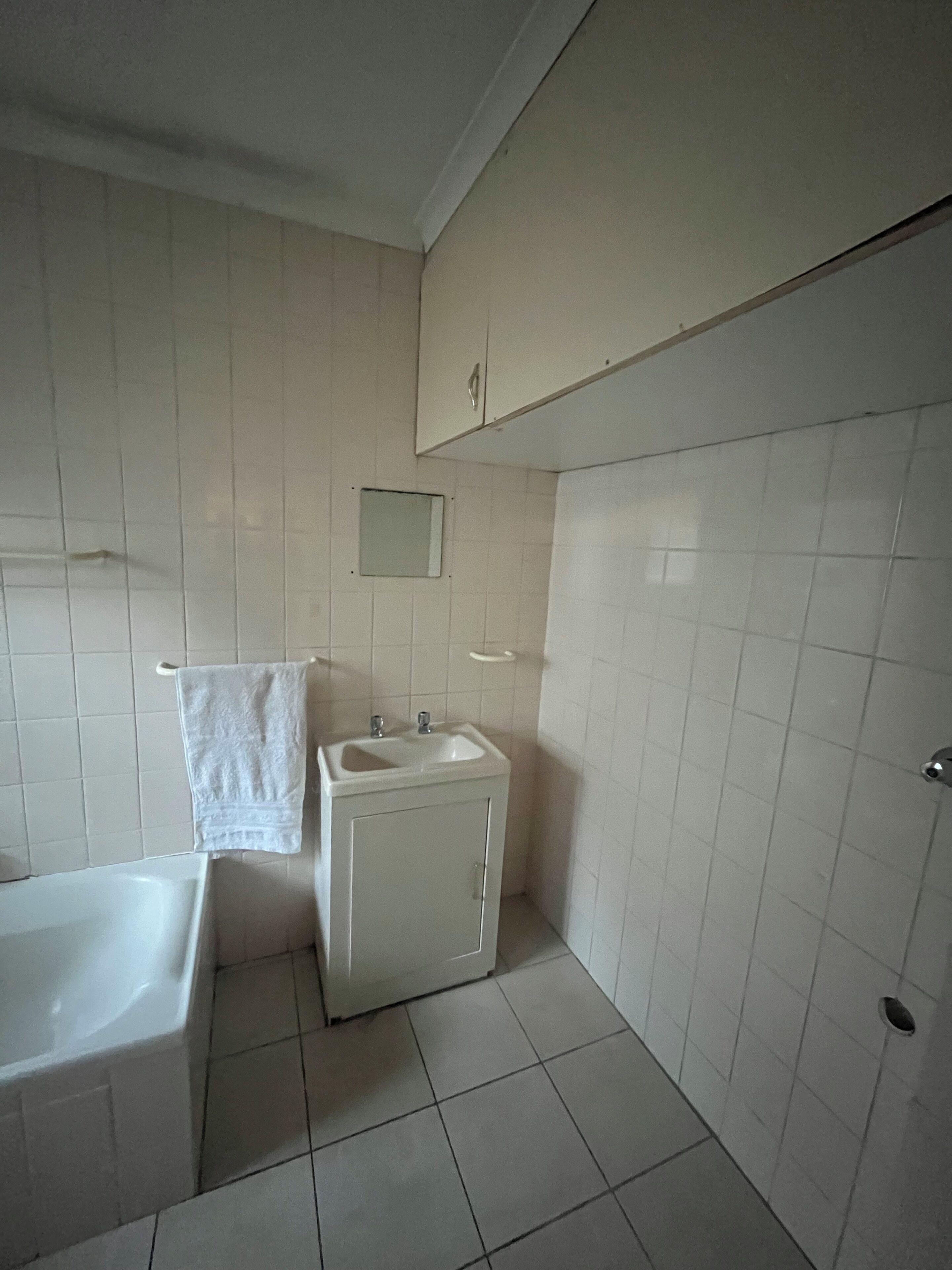 A bathroom with a bathtub, a sink, and a cabinet.