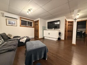 A living room with a sofa, a television, and a cabinet.