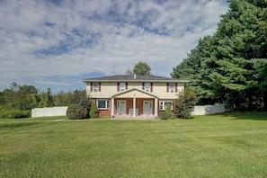 A two-story house with a front porch, a garage, and a well-maintained lawn.