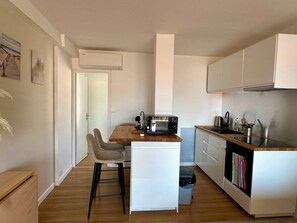 A compact kitchen with a wooden countertop, a microwave, and a sink. - Ocean view • Beach 90 m away • Serves 6 • Air Conditioning • Parking (Saint-Mandrier-sur-Mer)